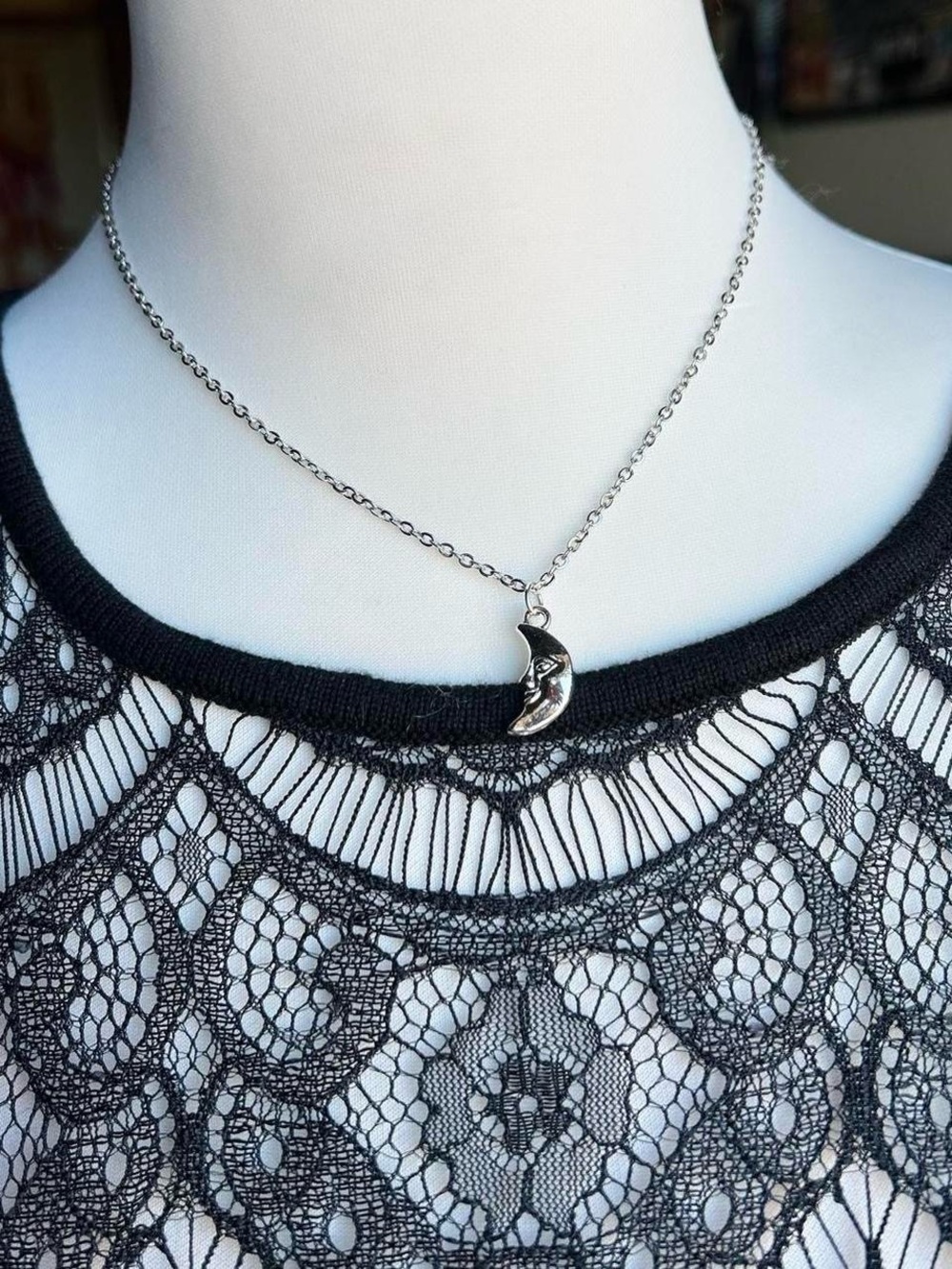 Silver moon necklace with little star detail on a dainty chain